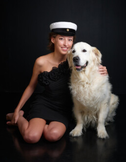 Ylioppilaskuva koiran kanssa mustalla taustalla