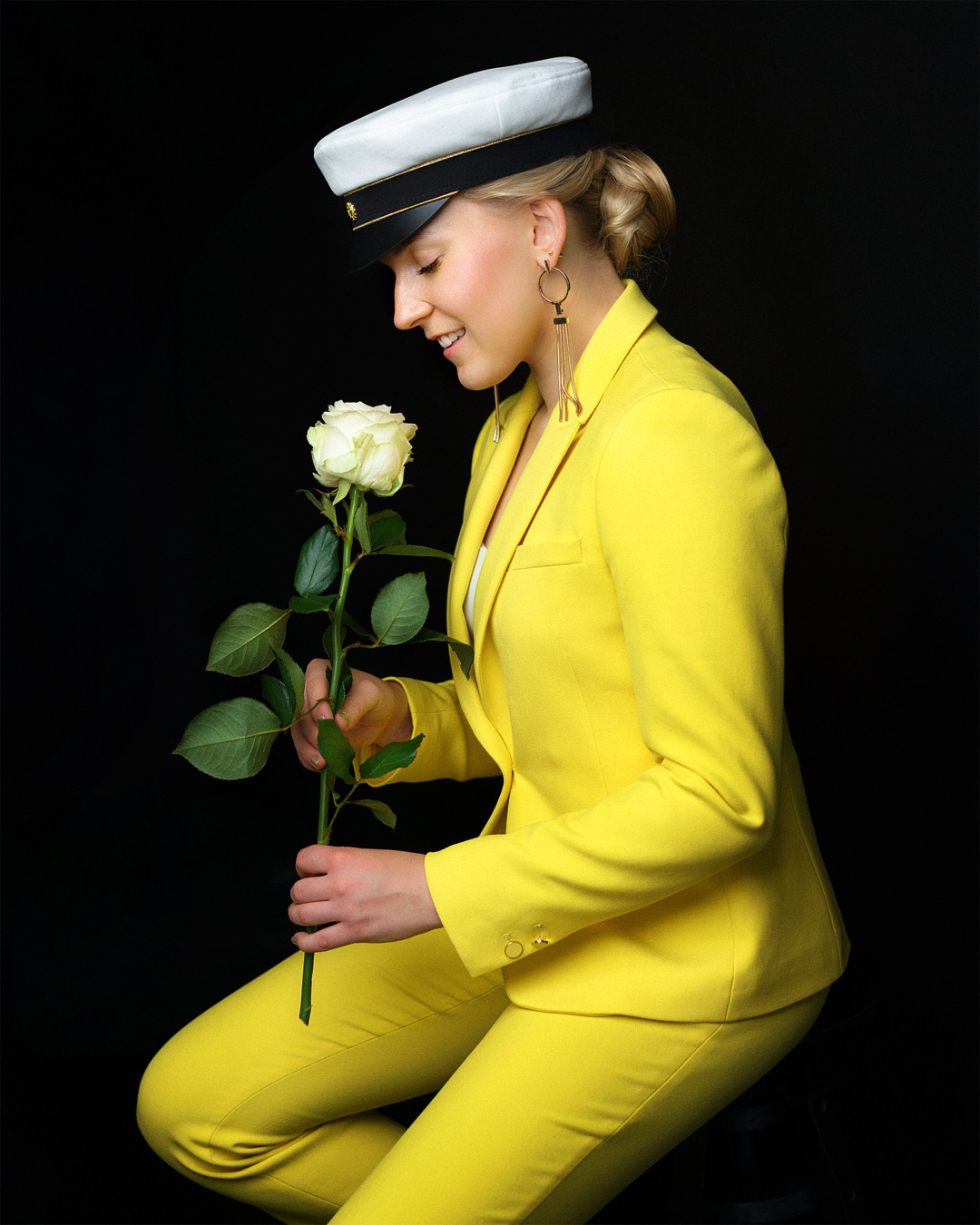 Ylioppilaskuva tyylikkään keltaisessa jakkupuvussa, sivuprofiili